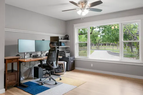 a view of a workspace with furniture and a window