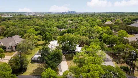 an aerial view of residential houses with outdoor space and trees