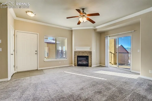 an empty room with windows and fireplace