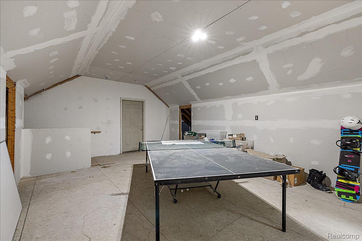 4219 Gardner Road Metamora, MI 48455 - Photo 57 of 84 Spacious unfinished bonus room featuring vaulted ceilings, exposed drywall, and a functional door