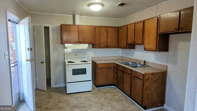 a kitchen with granite countertop a refrigerator stove and sink