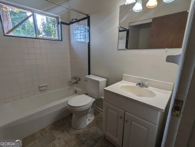 a bathroom with a toilet a sink a mirror and a bathtub