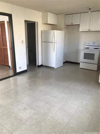 a view of a kitchen with refrigerator and white cabinets