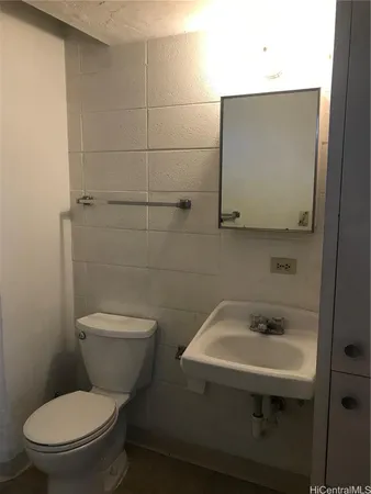 a white toilet sitting next to a bathroom sink