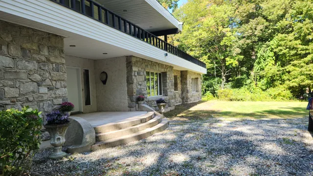 a view of a house with backyard and sitting area