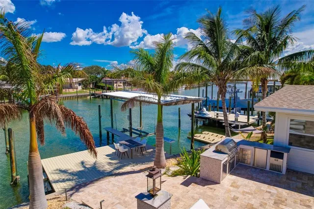 a patio with a table and chairs and potted plants