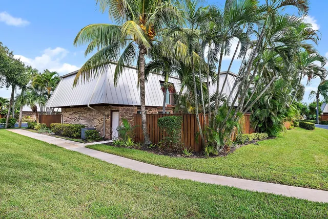 a view of a house with a yard and potted plants