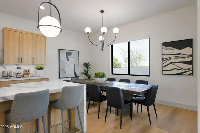a dining room with wooden floor a chandelier a wooden table and chairs
