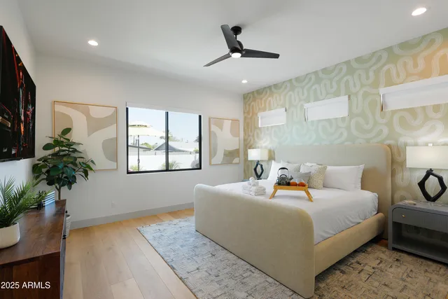 a bedroom with a bed a mirror and a potted plant