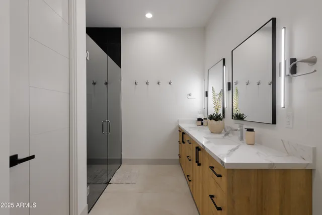 a bathroom with double vanity and a mirror