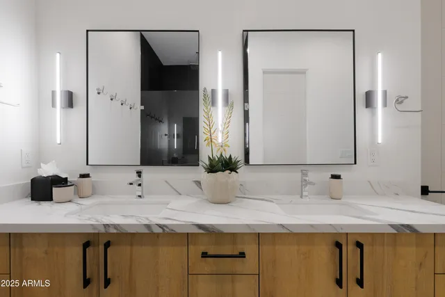 a bathroom with double sink and a mirror