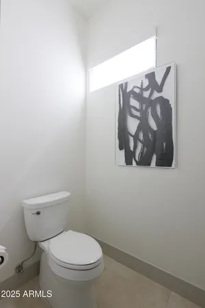 a white toilet sitting next to a white sink and vanity