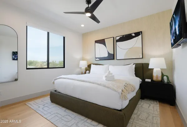 a bedroom with a bed mirror and window