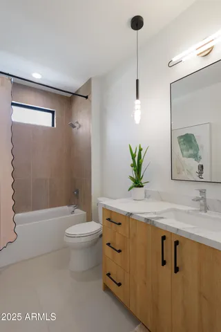 a bathroom with a granite countertop sink a toilet and a mirror