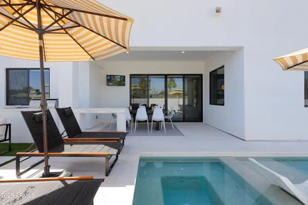 a living room with furniture and a dining table with floor to ceiling window