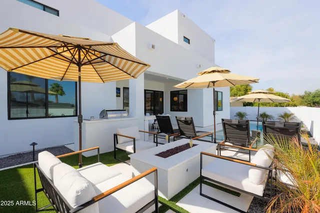 a view of a patio with a table and chairs under an umbrella
