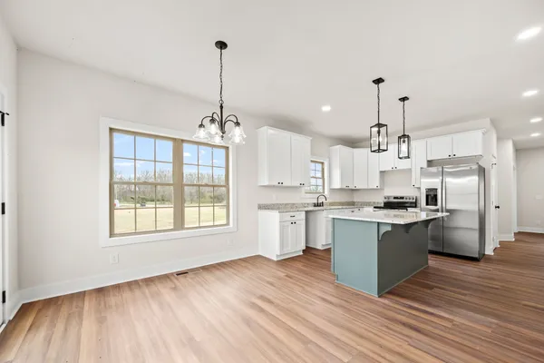 a kitchen with stainless steel appliances granite countertop a sink stove and wooden floor