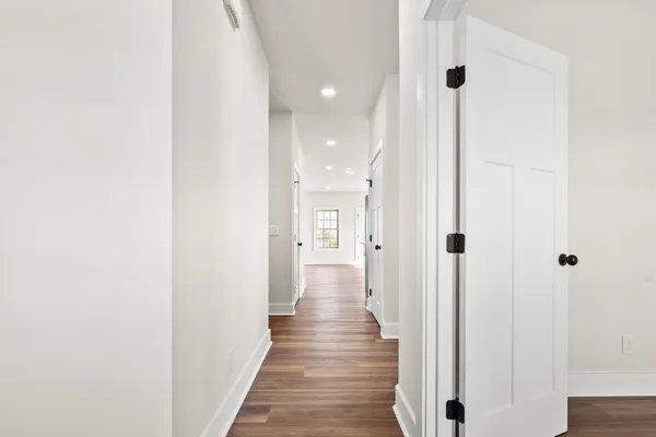 a view of a hallway with wooden floor