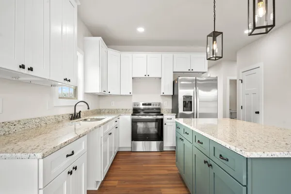a kitchen with granite countertop a sink stainless steel appliances and cabinets