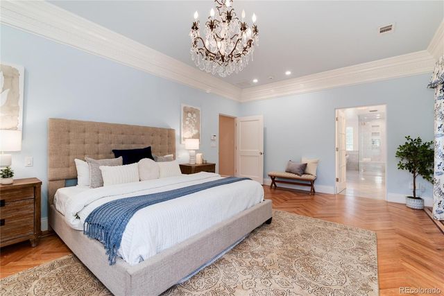 a living room with furniture chandelier and wooden floor