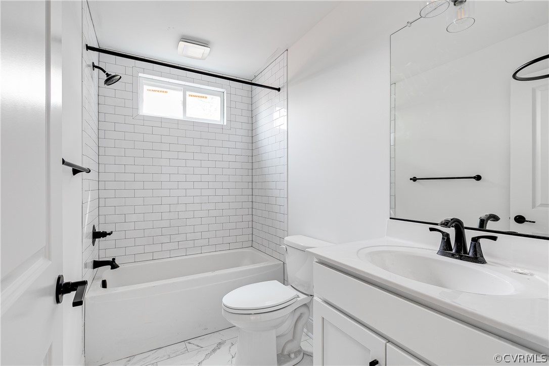 2403 Everett Street Richmond, VA 23224 - Photo 18 of 25 a bathroom with a sink a toilet a mirror a bathtub and shower