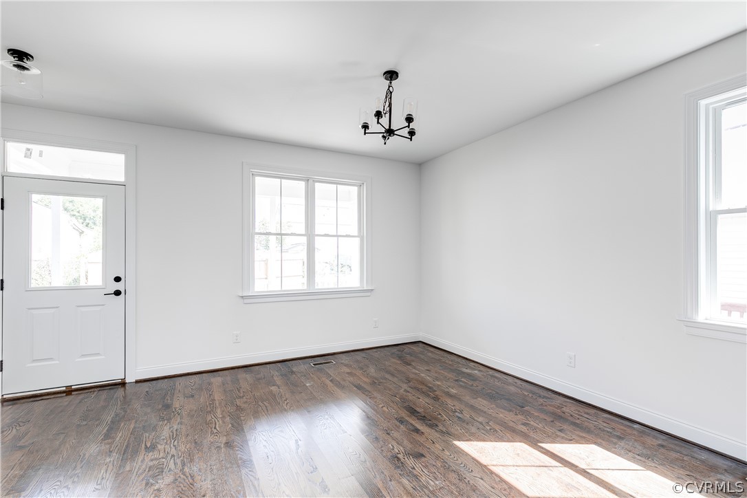 2403 Everett Street Richmond, VA 23224 - Photo 5 of 25 an empty room with wooden floor chandelier and windows