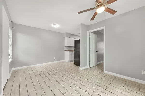a view of an empty room and chandelier fan
