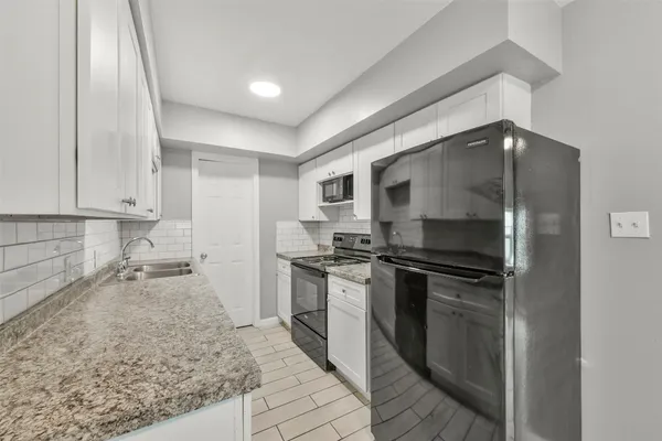 a kitchen with stainless steel appliances granite countertop a sink and a stove