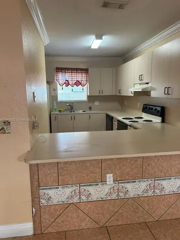 a kitchen with stainless steel appliances granite countertop a sink and a stove