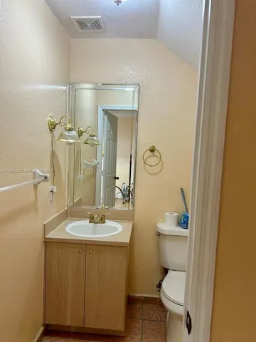 a bathroom with a sink a toilet a mirror and vanity
