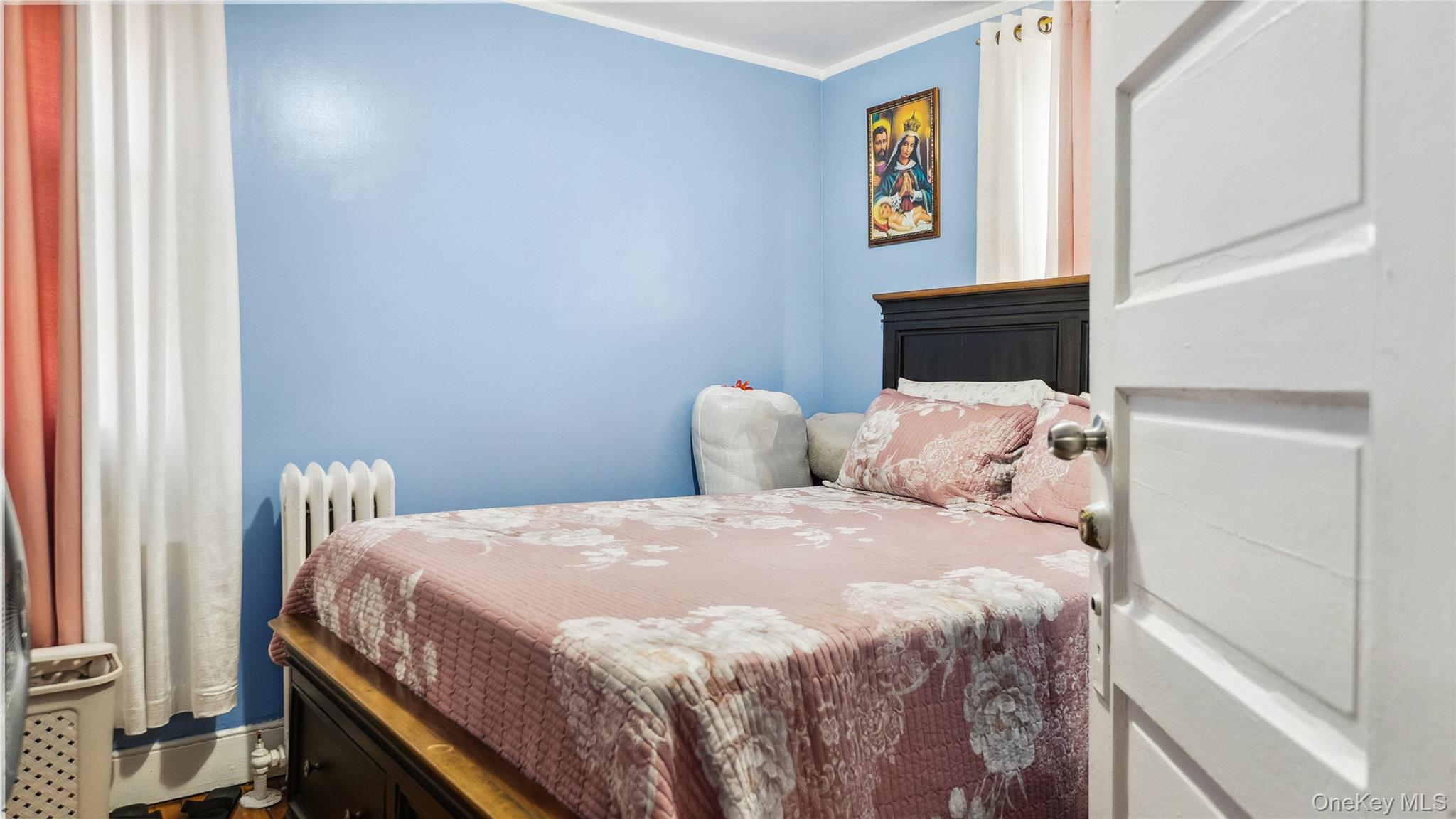 56-12 135th Street Queens, NY 11355 - Photo 13 of 23 a bedroom with a bed and a window