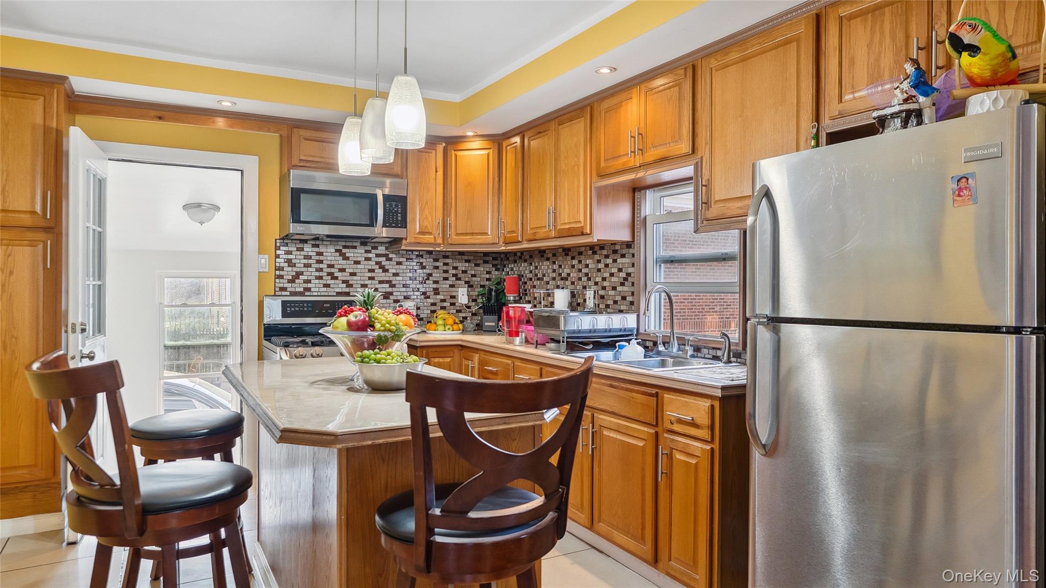 56-12 135th Street Queens, NY 11355 - Photo 6 of 23 a kitchen with refrigerator and chairs