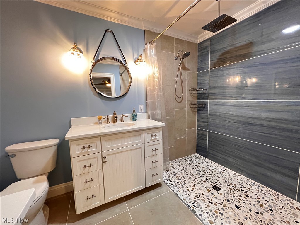6213 Lake Road West Ashtabula, OH 44004 - Photo 23 of 30 Bathroom featuring vanity, crown molding, walk in shower, toilet, and tile floors