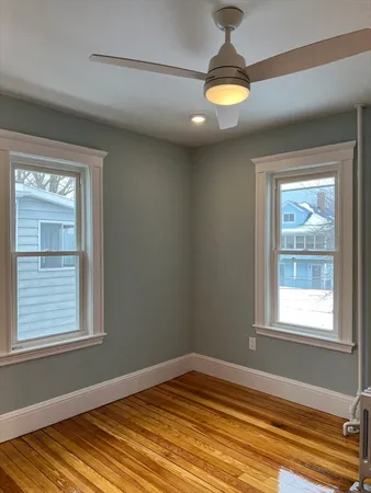 a view of empty room with window and wooden floor