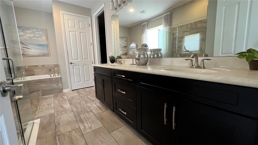 714 Riviera Bella Drive DeBary, FL 32713 - Photo 25 of 50 a en suite bathroom with a double vanity sink a mirror and a shower