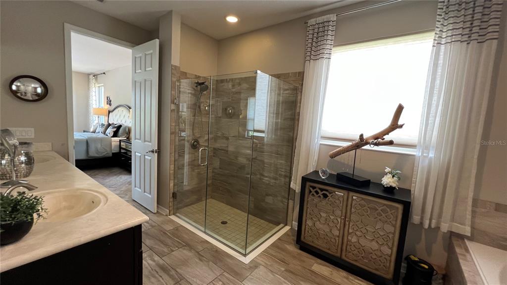 714 Riviera Bella Drive DeBary, FL 32713 - Photo 27 of 50 a bathroom with a granite countertop sink a mirror and shower