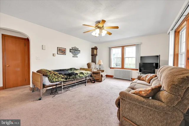 a living room with furniture a window and a flat screen tv