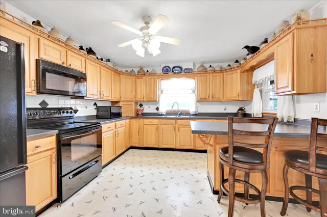 a kitchen with stainless steel appliances granite countertop a stove a sink a microwave and a refrigerator