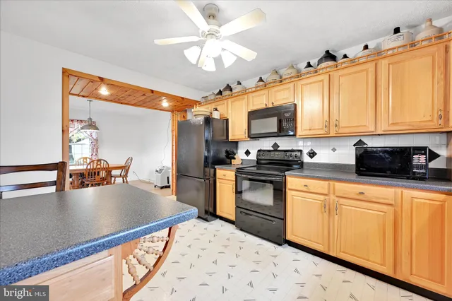 a kitchen with kitchen island granite countertop a sink appliances cabinets and a counter top space