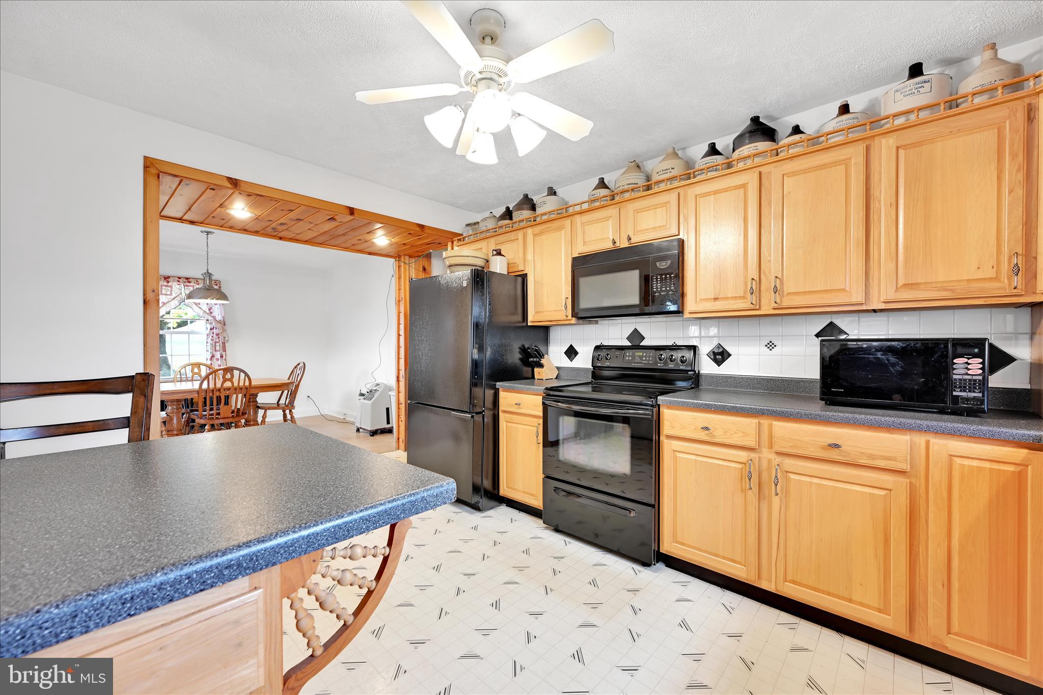 209 Ridge Road Pitman, PA 17964 - Photo 21 of 41 a kitchen with kitchen island granite countertop a sink appliances cabinets and a counter top space