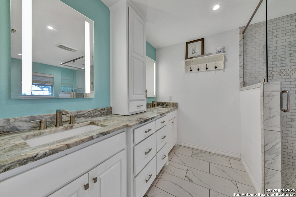 15592 Miller Road St. Hedwig, TX 78152 - Photo 17 of 47 a bathroom with a granite countertop sink mirror and double