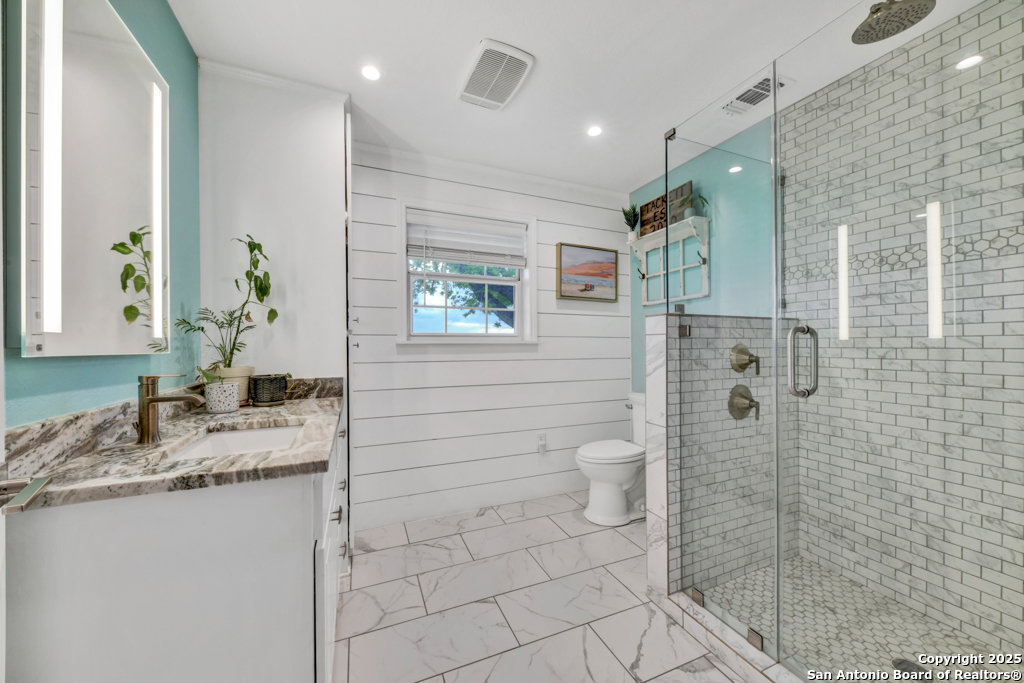 15592 Miller Road St. Hedwig, TX 78152 - Photo 21 of 47 a bathroom with a granite countertop sink a toilet and shower