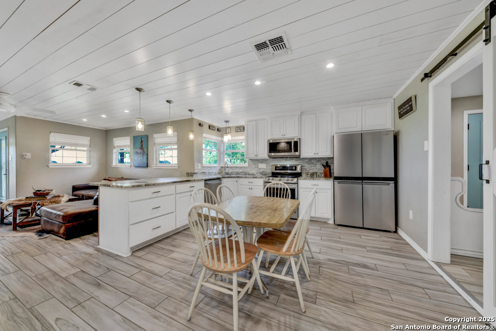 15592 Miller Road St. Hedwig, TX 78152 - Photo 10 of 47 a kitchen with stainless steel appliances kitchen island granite countertop a refrigerator and microwave