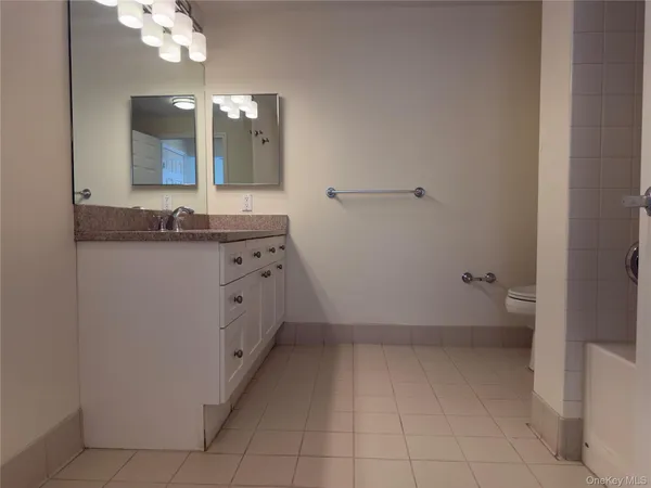 a bathroom with a granite countertop sink a mirror and a vanity