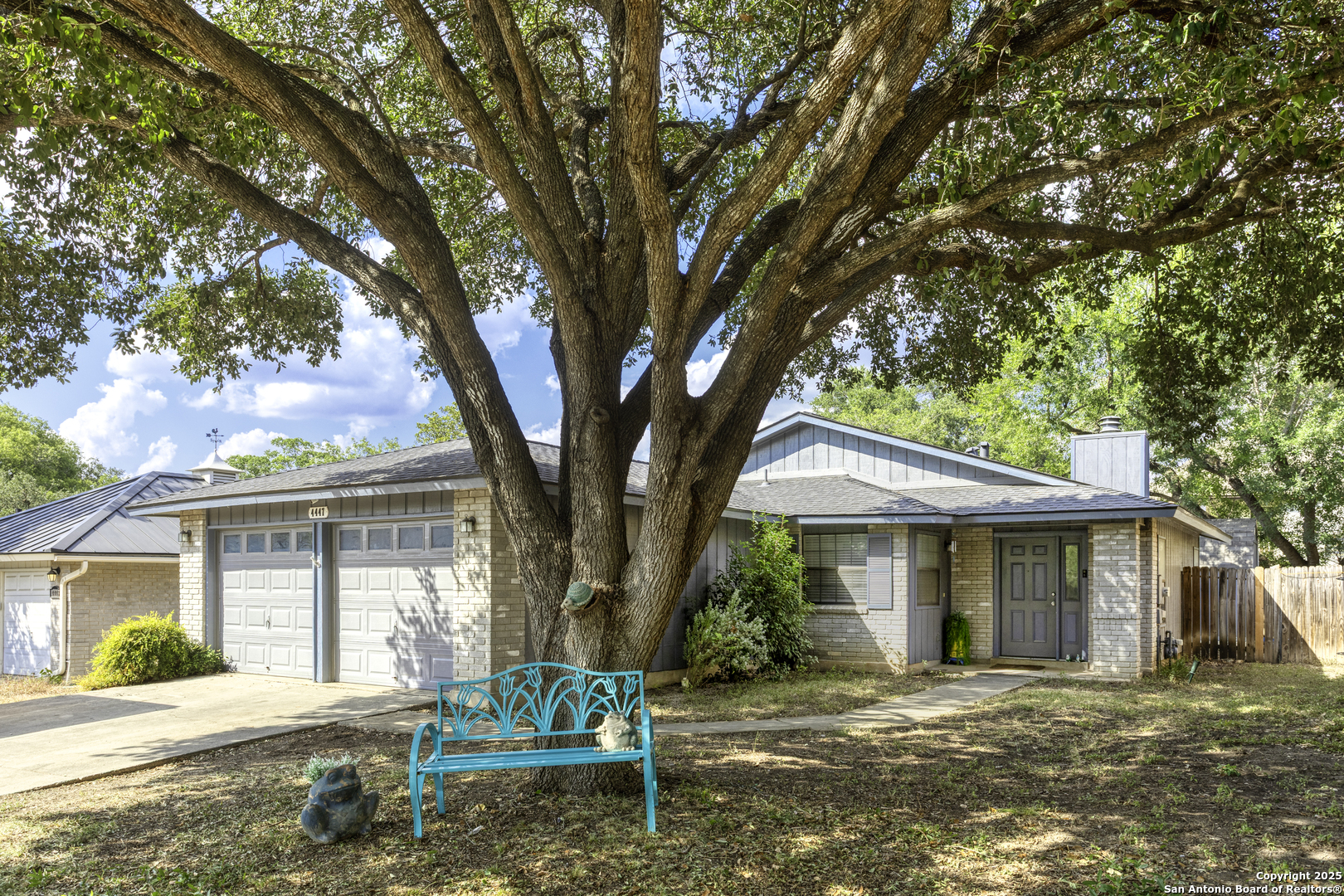4447 Brushy Hill San Antonio, TX 78217 - Photo 2 of 13 a front view of a house with a tree and wooden fence