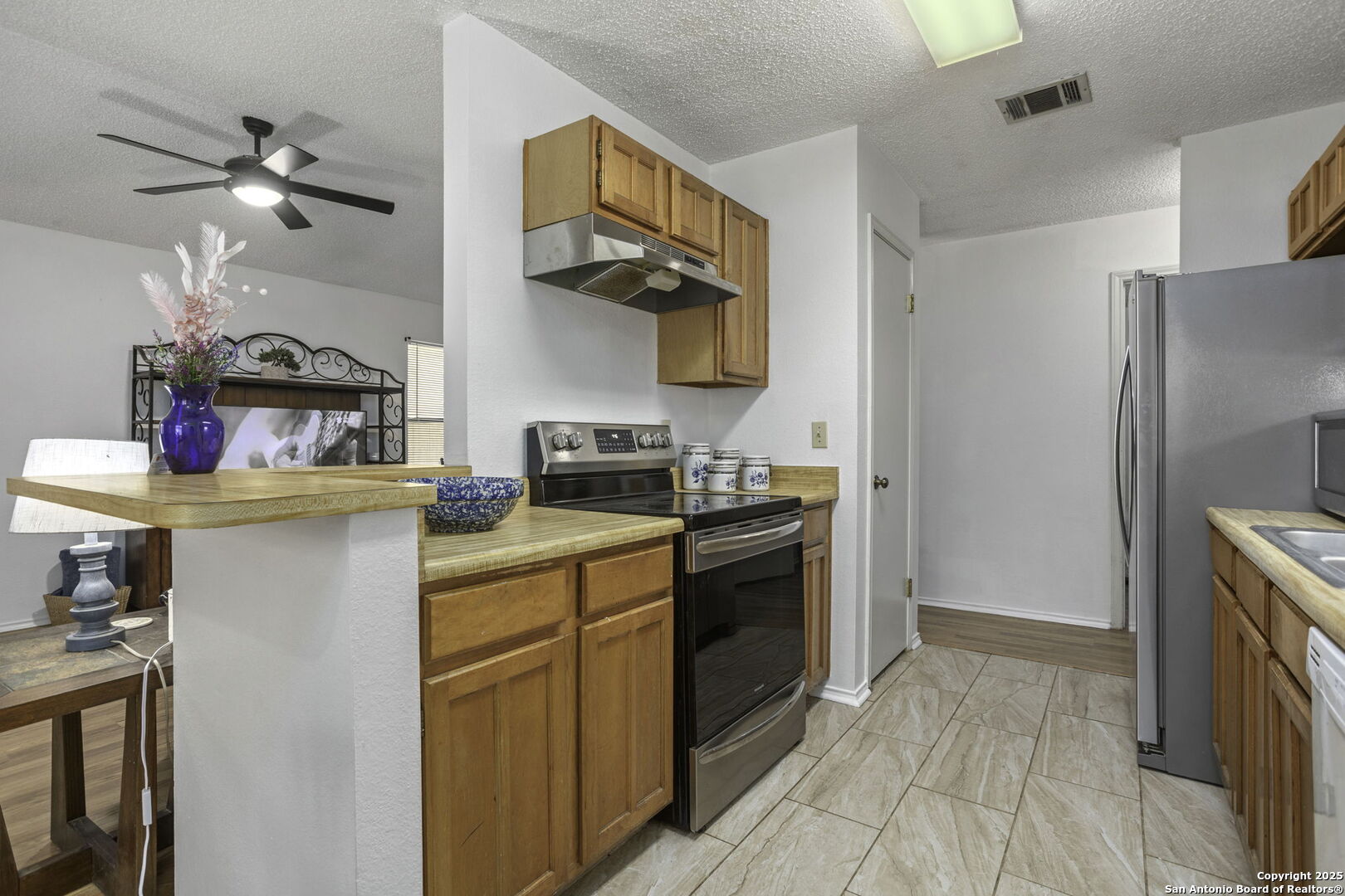 4447 Brushy Hill San Antonio, TX 78217 - Photo 6 of 13 a kitchen with stainless steel appliances granite countertop a refrigerator a stove and a sink with wooden floor
