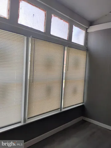 an empty room with wooden floor and a window