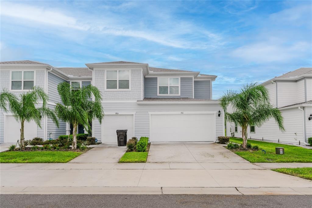 a front view of a house with a yard and a garage