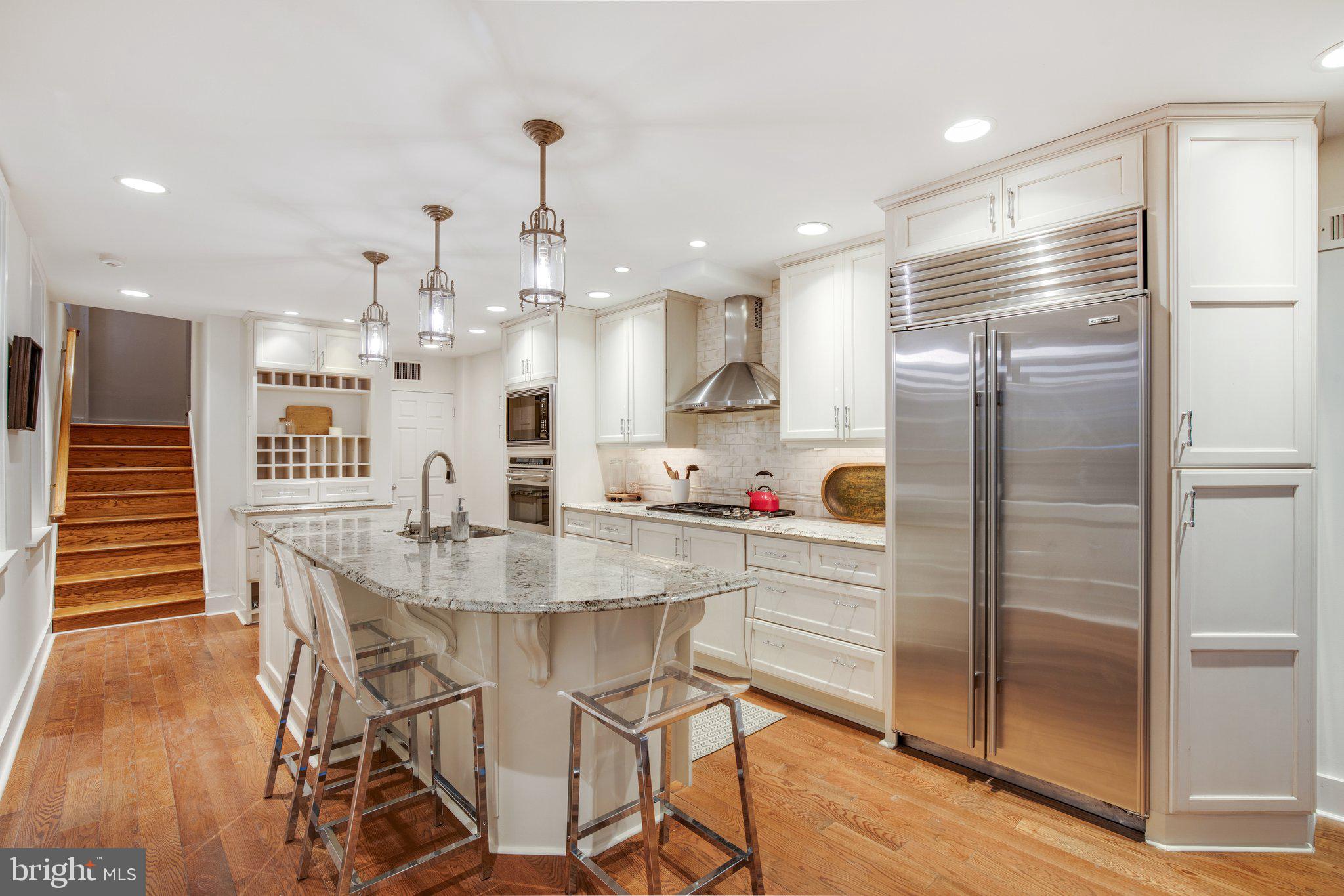 2221 Locust Street Philadelphia, PA 19103 - Photo 14 of 70 a kitchen with kitchen island a refrigerator and a wooden floor