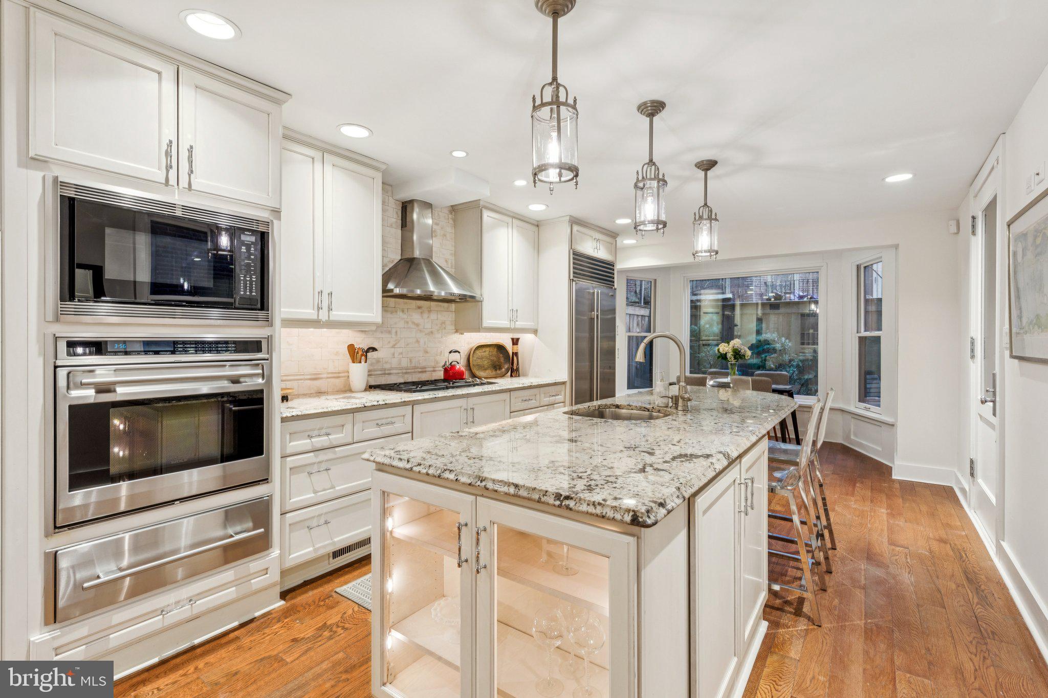 2221 Locust Street Philadelphia, PA 19103 - Photo 16 of 70 a kitchen with stainless steel appliances granite countertop a stove top oven a sink dishwasher and white cabinets with wooden floor